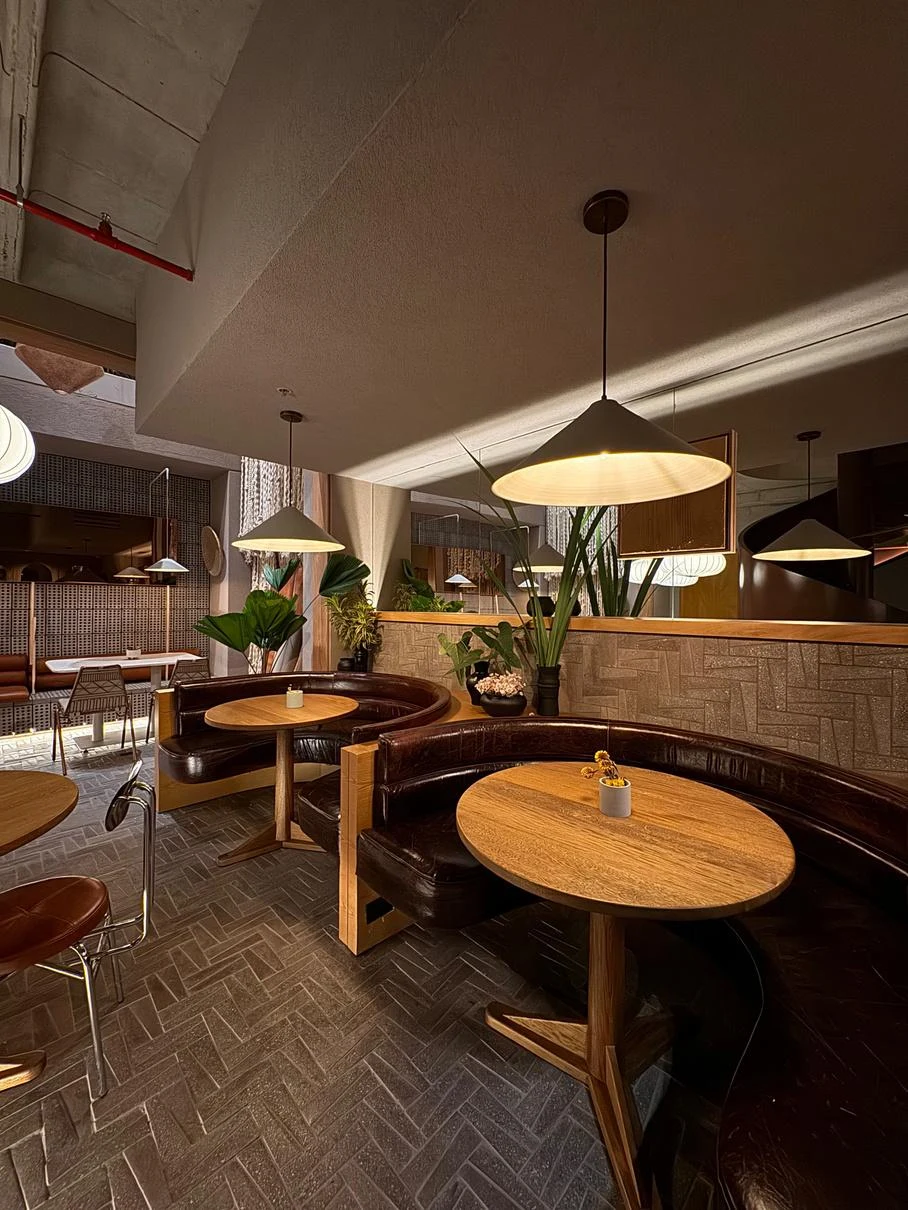 Interior del restaurante La Hija Mía en Provenza, Medellín, con mesas, iluminación y acabados industriales